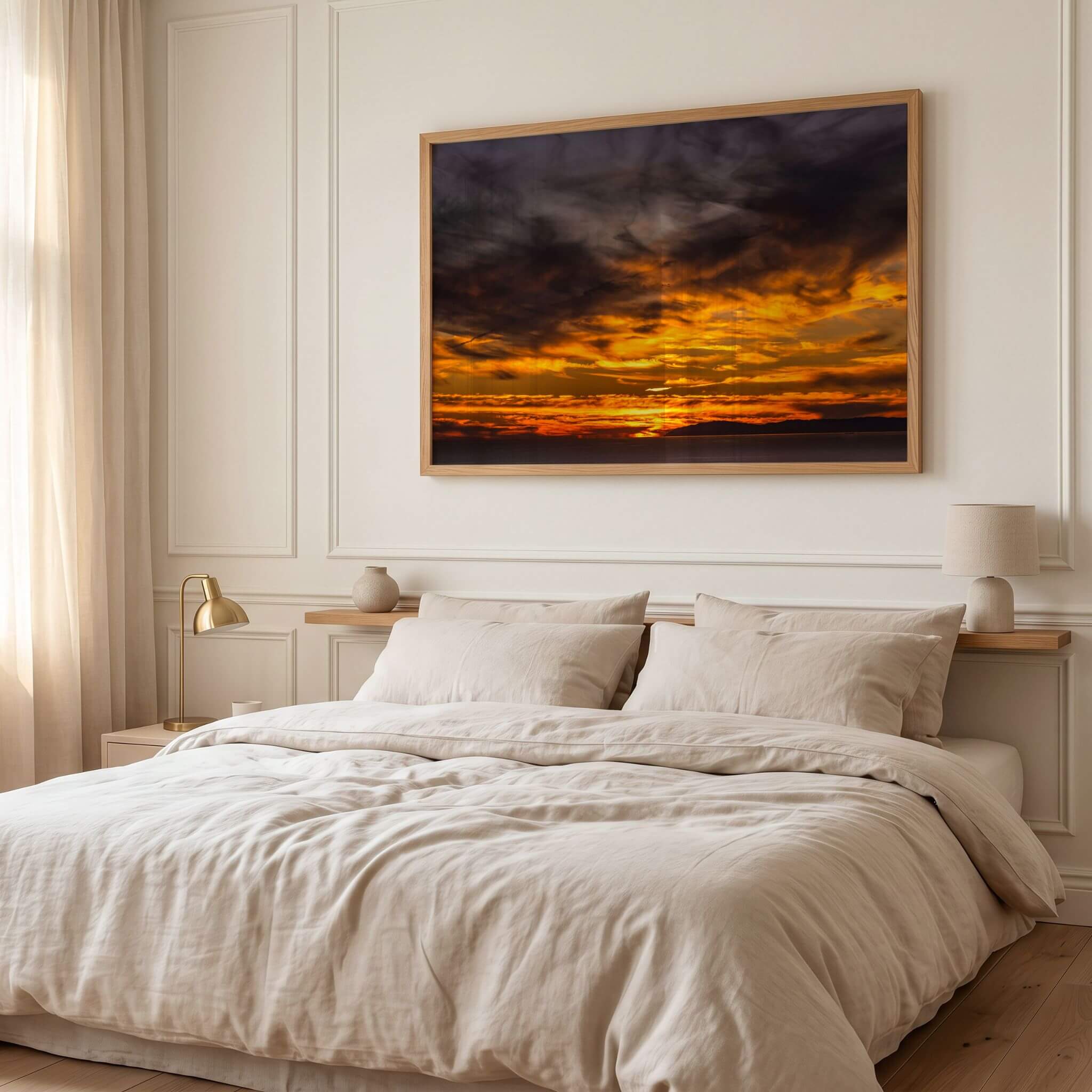 Golden sunset cloudscape wall art framed displayed above a bed, featuring dramatic golden clouds, a glowing Pacific Ocean sunset, and the distant California coastline.