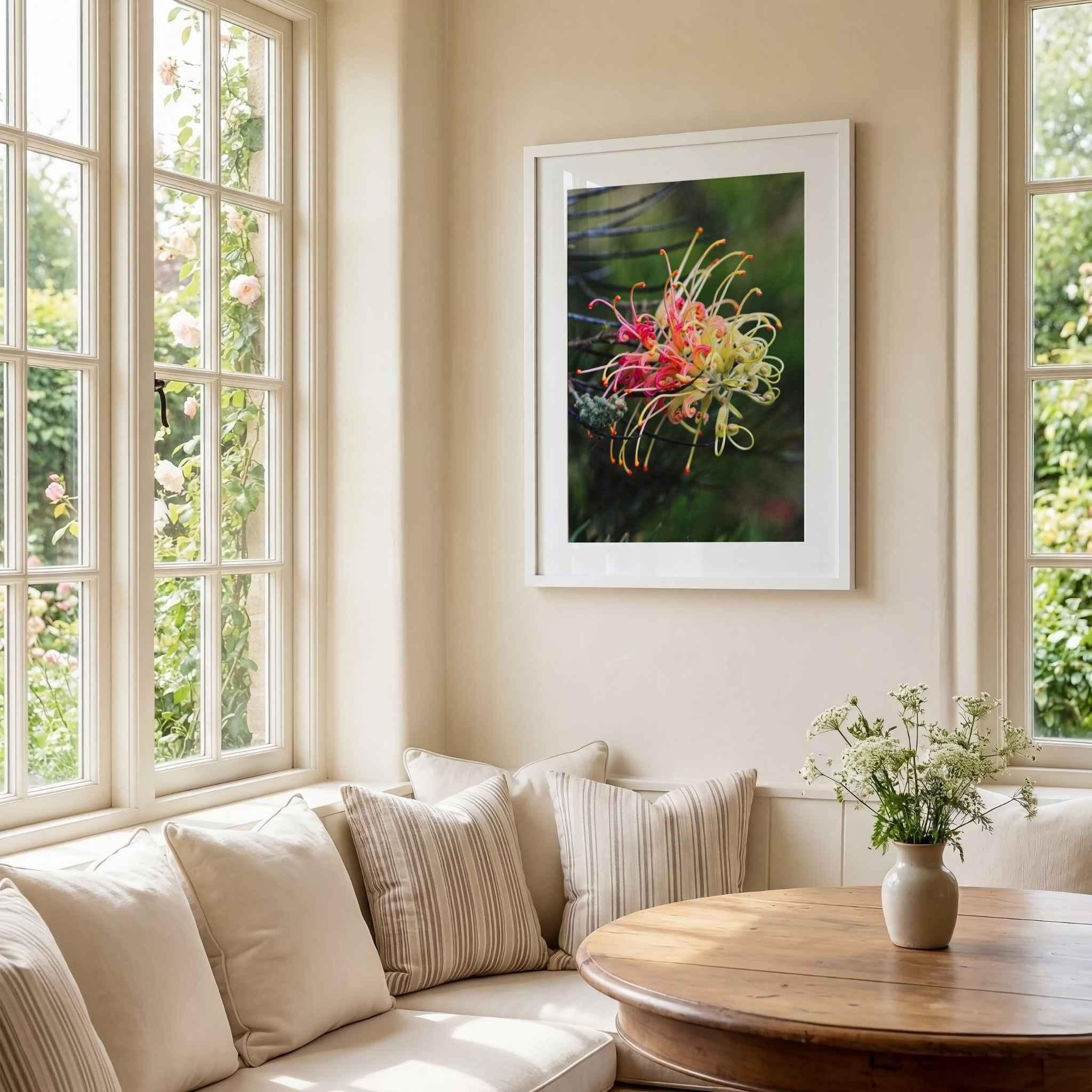 Grevillea Peaches and Cream fine art print in a white frame displayed above a built-in dining nook with a round oak table, soft neutral cushions, and sunlit windows by Abigail Diane Photography.