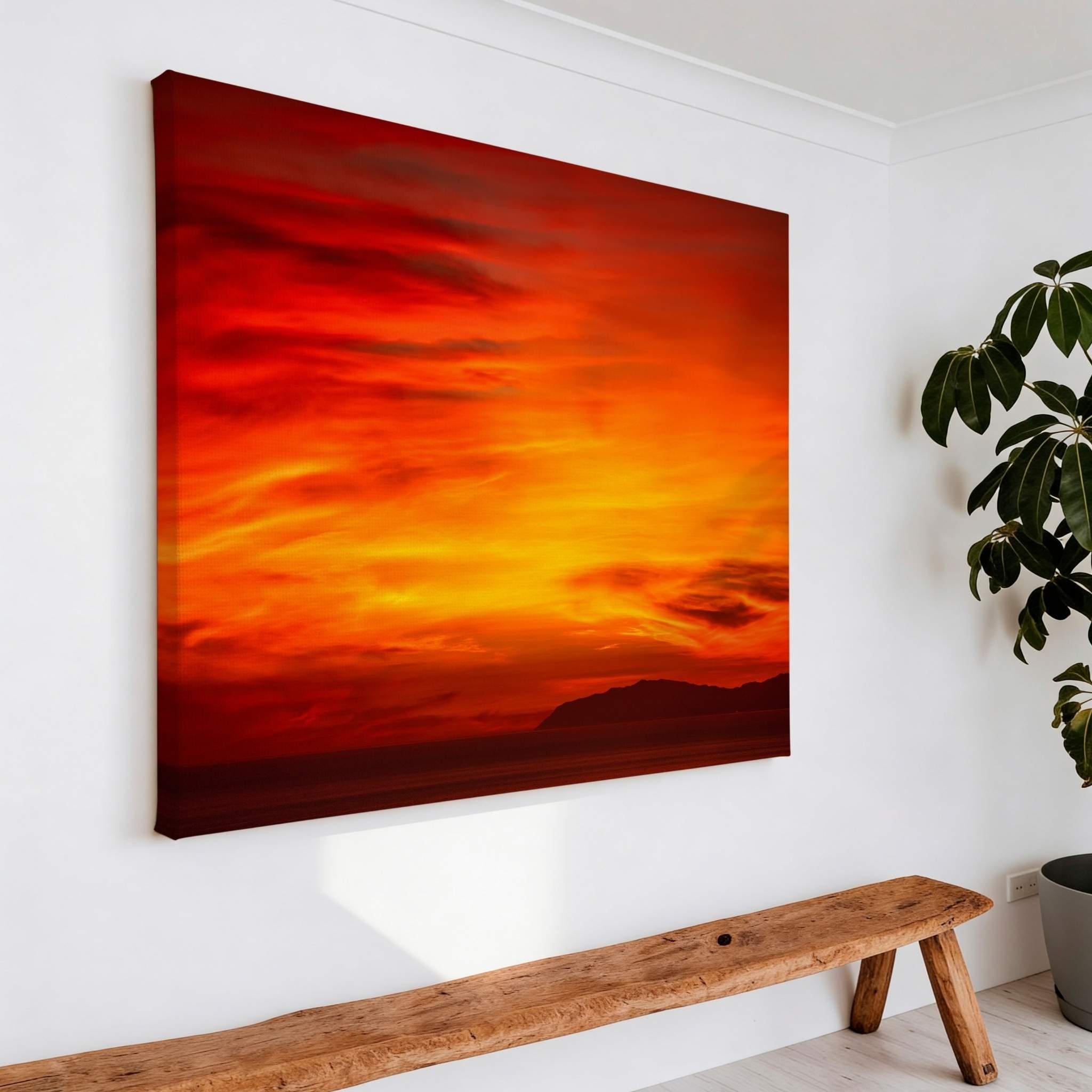 Gallery-wrapped canvas of Inferno Sunset displayed above a rustic wooden bench in a bright modern interior, featuring a fiery California sunset with the silhouette of Catalina Island. Fine art canvas wall décor by Abigail Diane Photography.