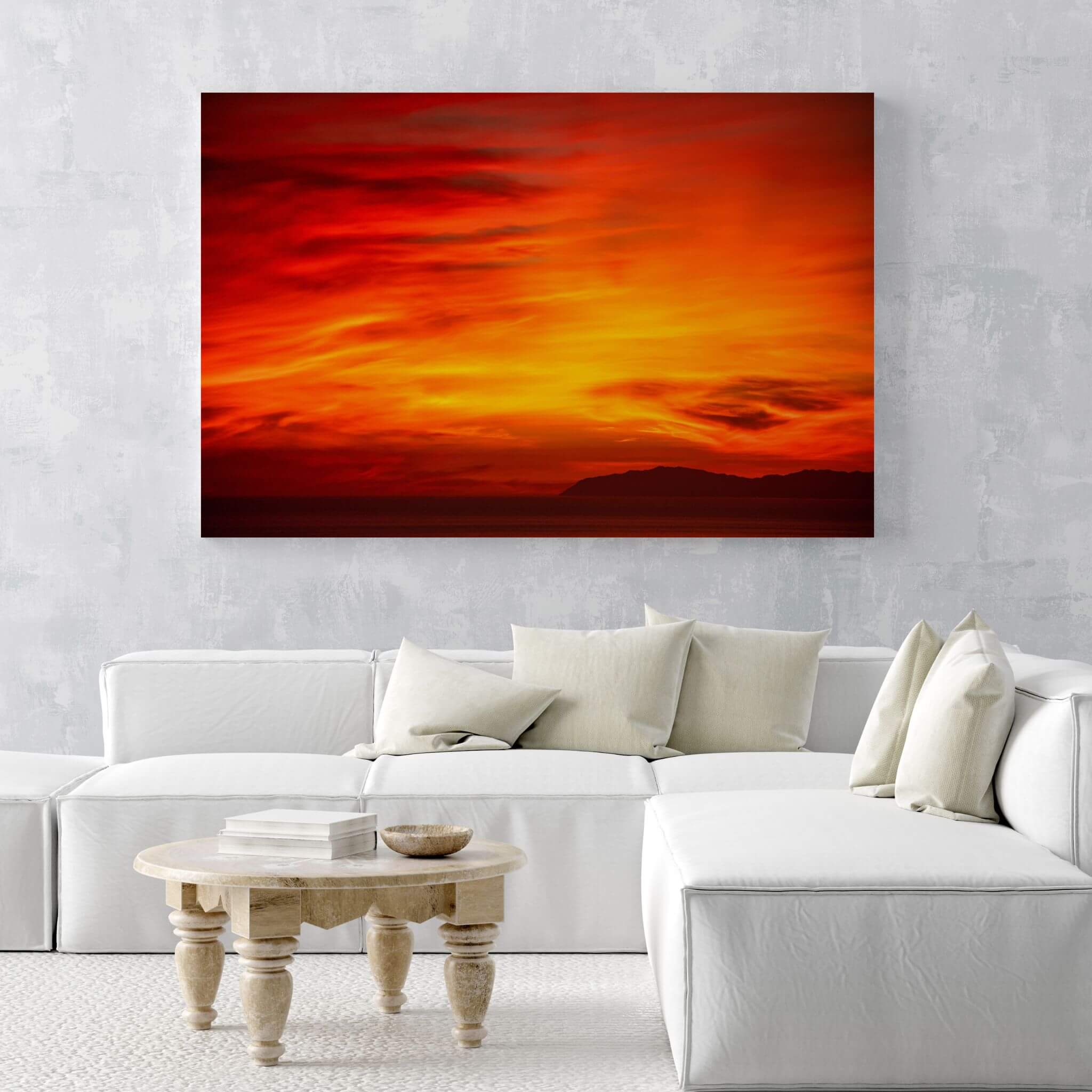 Inferno Sunset Catalina Island metal wall art displayed above a white sectional sofa in a bright contemporary living room.