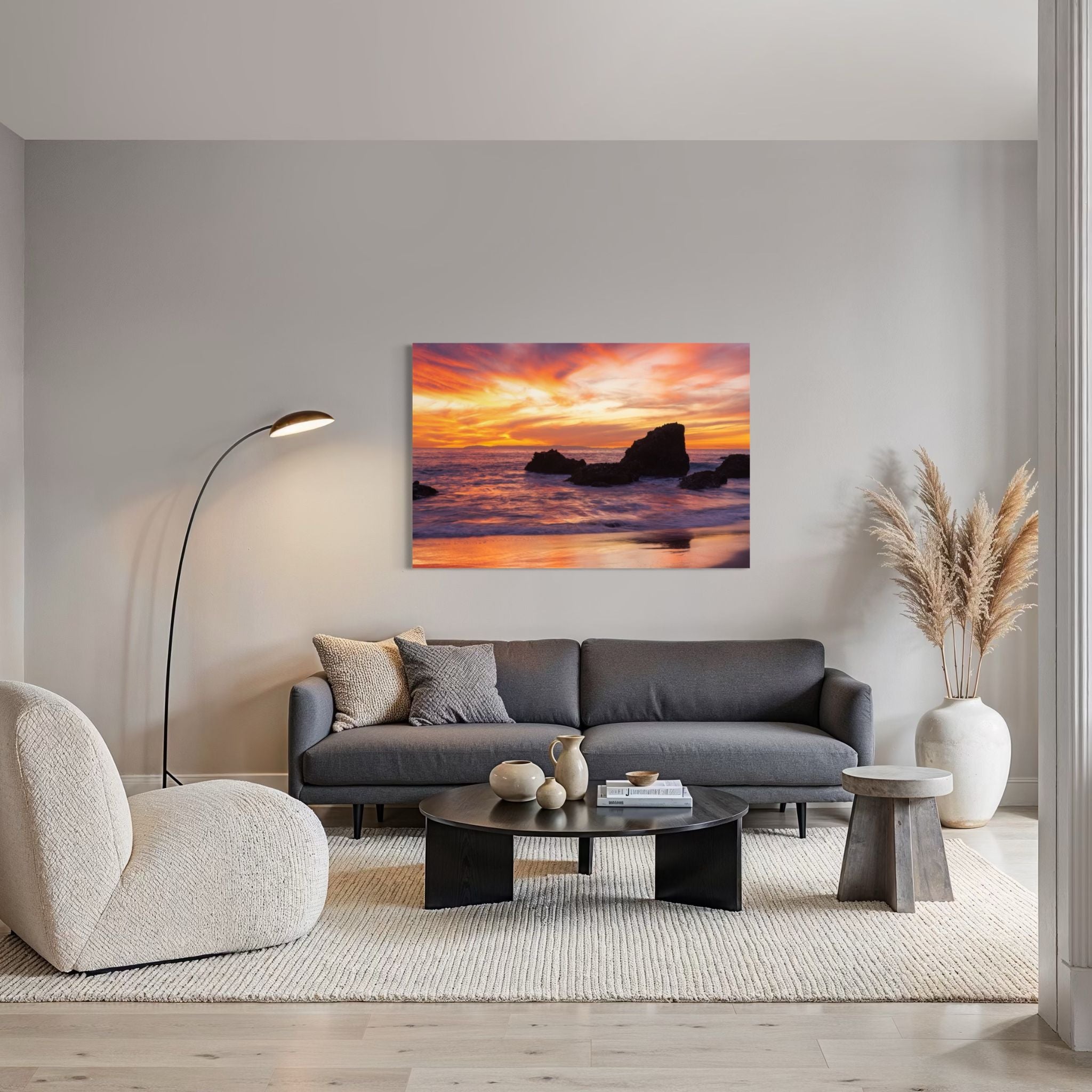 Modern living room featuring HD metal wall art of a vibrant sunset at Woods Cove, Laguna Beach, California, with glowing ocean reflections, dramatic coastal rocks, and colorful skies by Abigail Diane Photography.