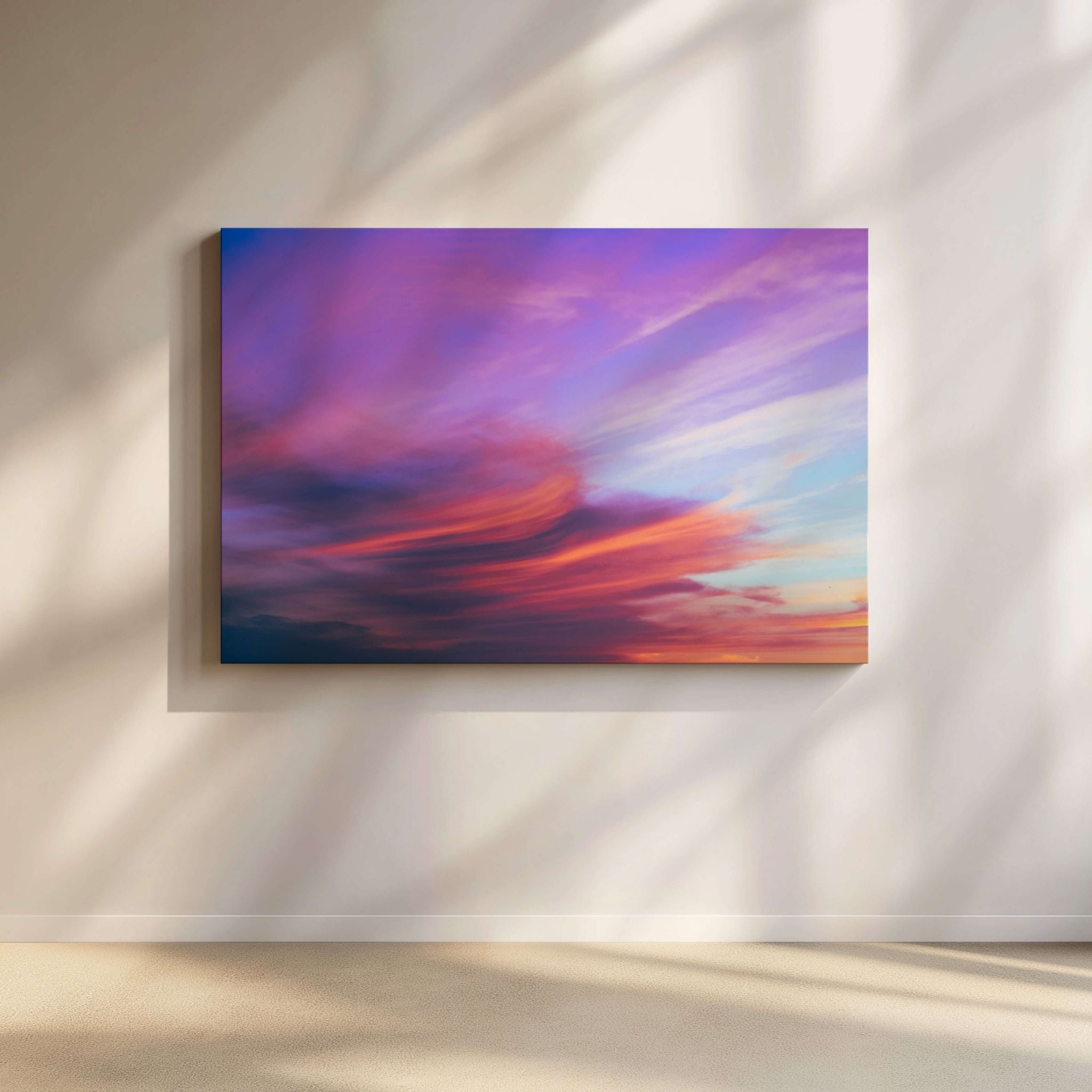  soft lavender, pink, and peach clouds illuminated by the setting sun above the Pacific Ocean. 

Lavender Dreams cloudscape wall art featuring a colorful abstract sky with purple, pink, orange, and blue clouds, displayed on a light beige wall with soft shadow patterns. Fine art cloudscape photograph by Abigail Diane Photography