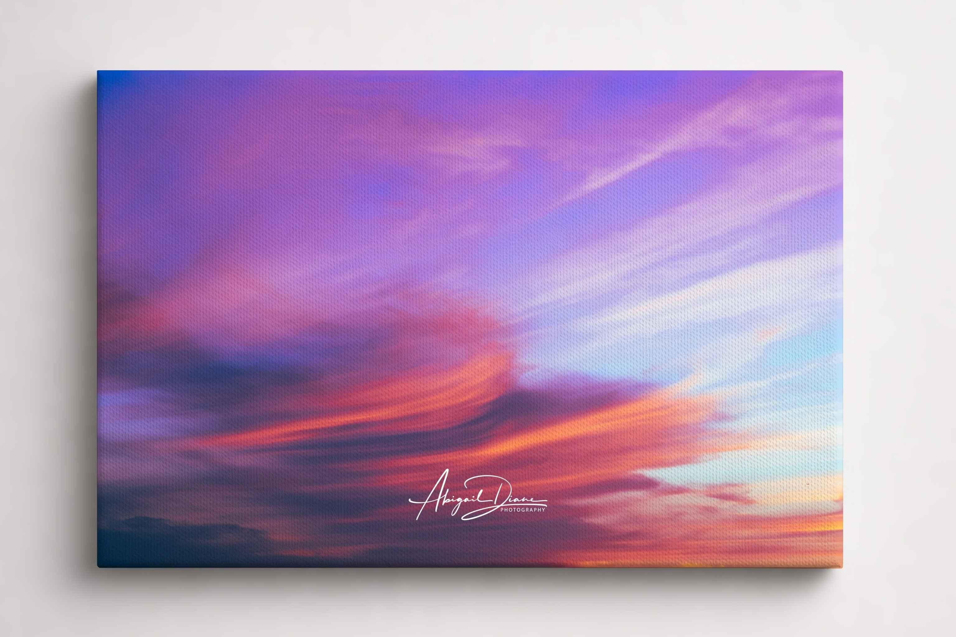  Lavender Dreams captures delicate lavender, blush pink, and soft blue clouds sweeping across the evening sky, creating a tranquil cloudscape sunset. Fine art canvas print by Abigail Diane Photography.