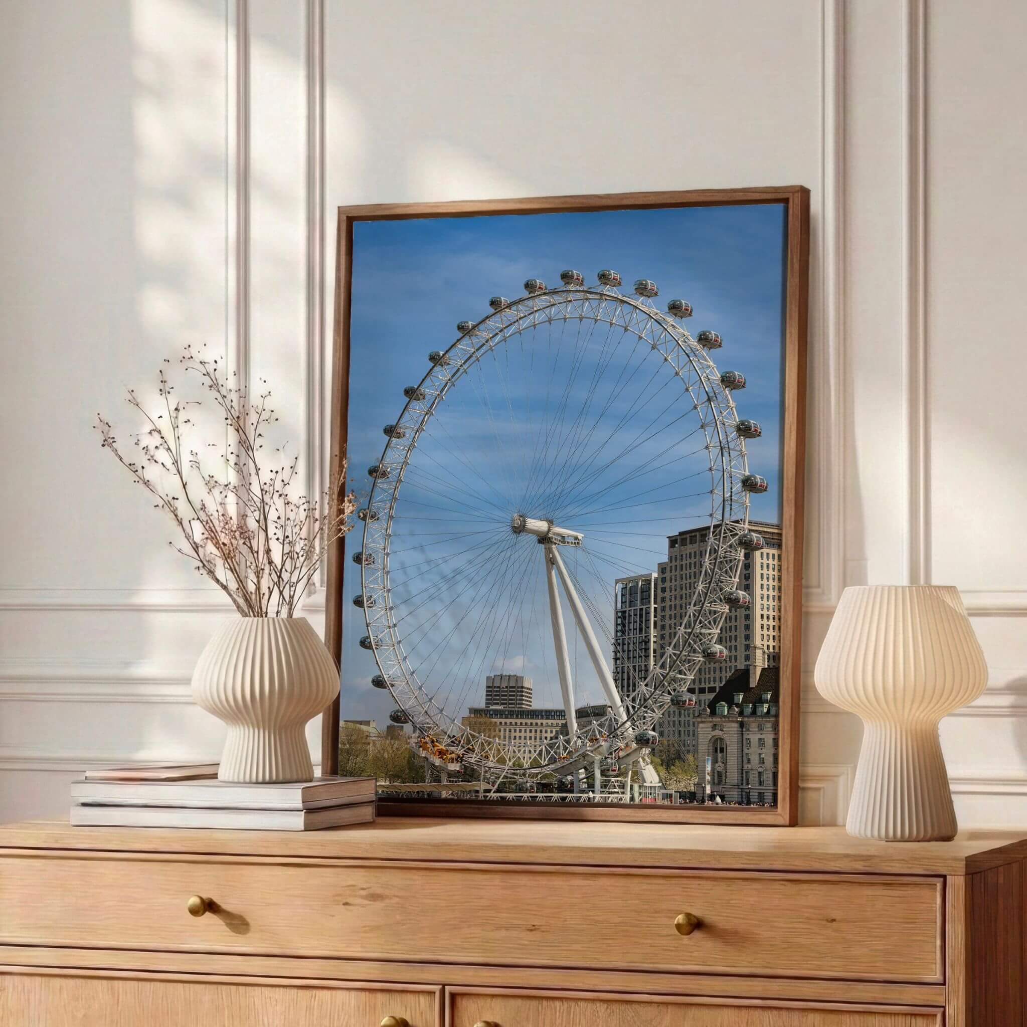 London Eye fine art print displayed in a natural wood frame on a wooden dresser in an elegant neutral interior.