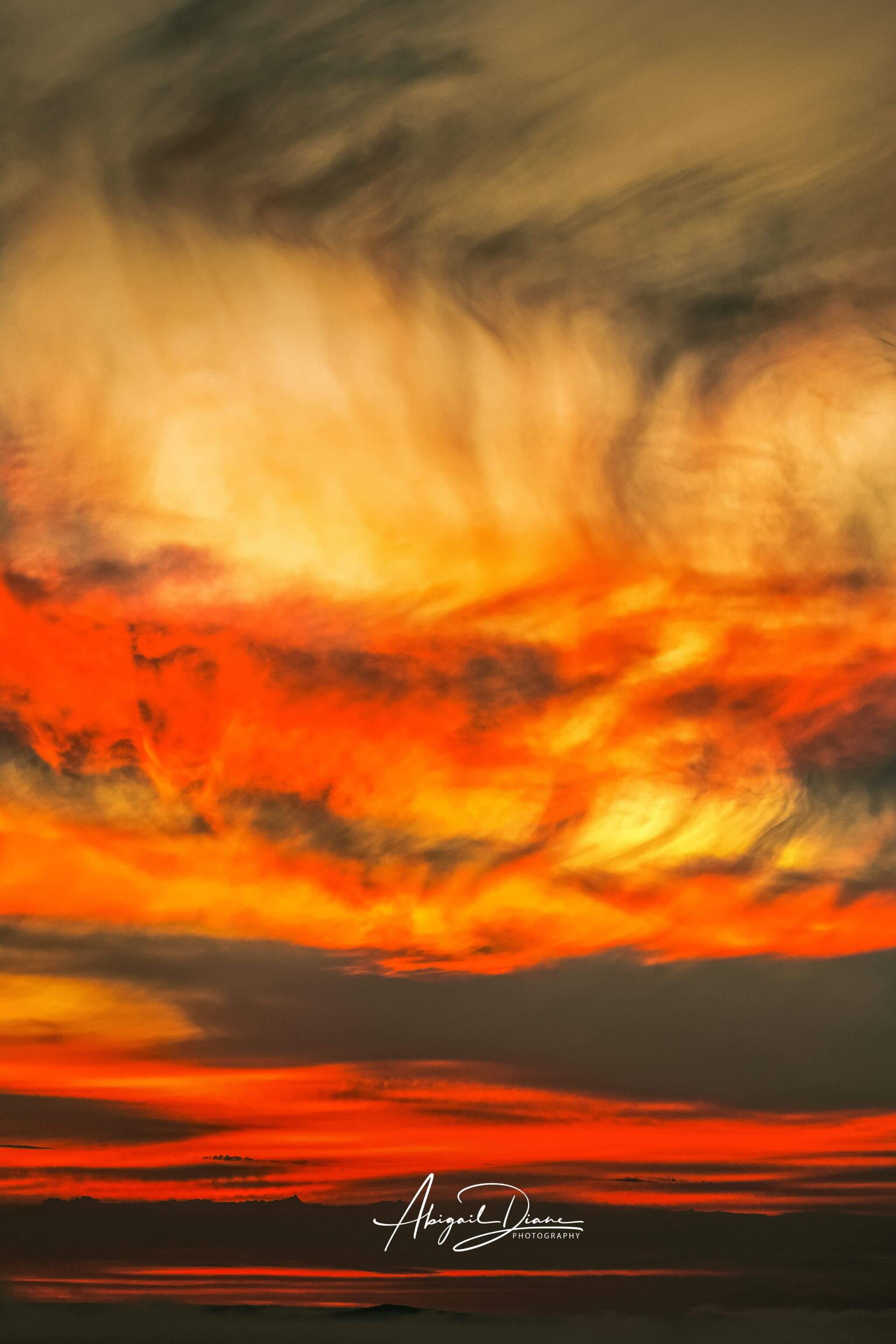 Painted Lady California sunset by Abigail Diane Photography, featuring luminous golden yellow, fiery orange, vivid red and deep charcoal clouds sweeping dramatically across the evening sky, presented as a High Definition metal print.