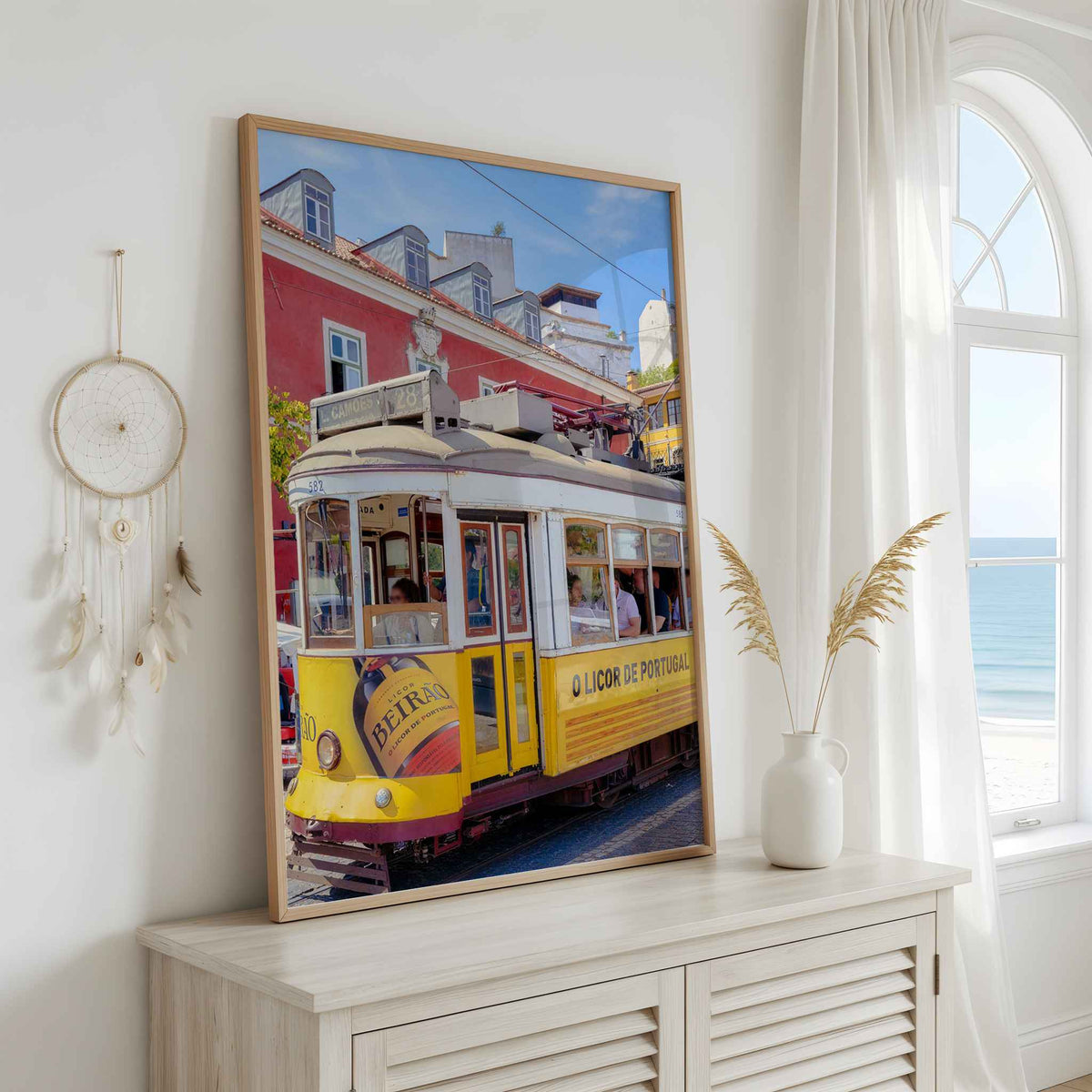 Riding Through Lisboa fine art framed print featuring a yellow Lisbon tram displayed in a bright coastal-inspired interior.