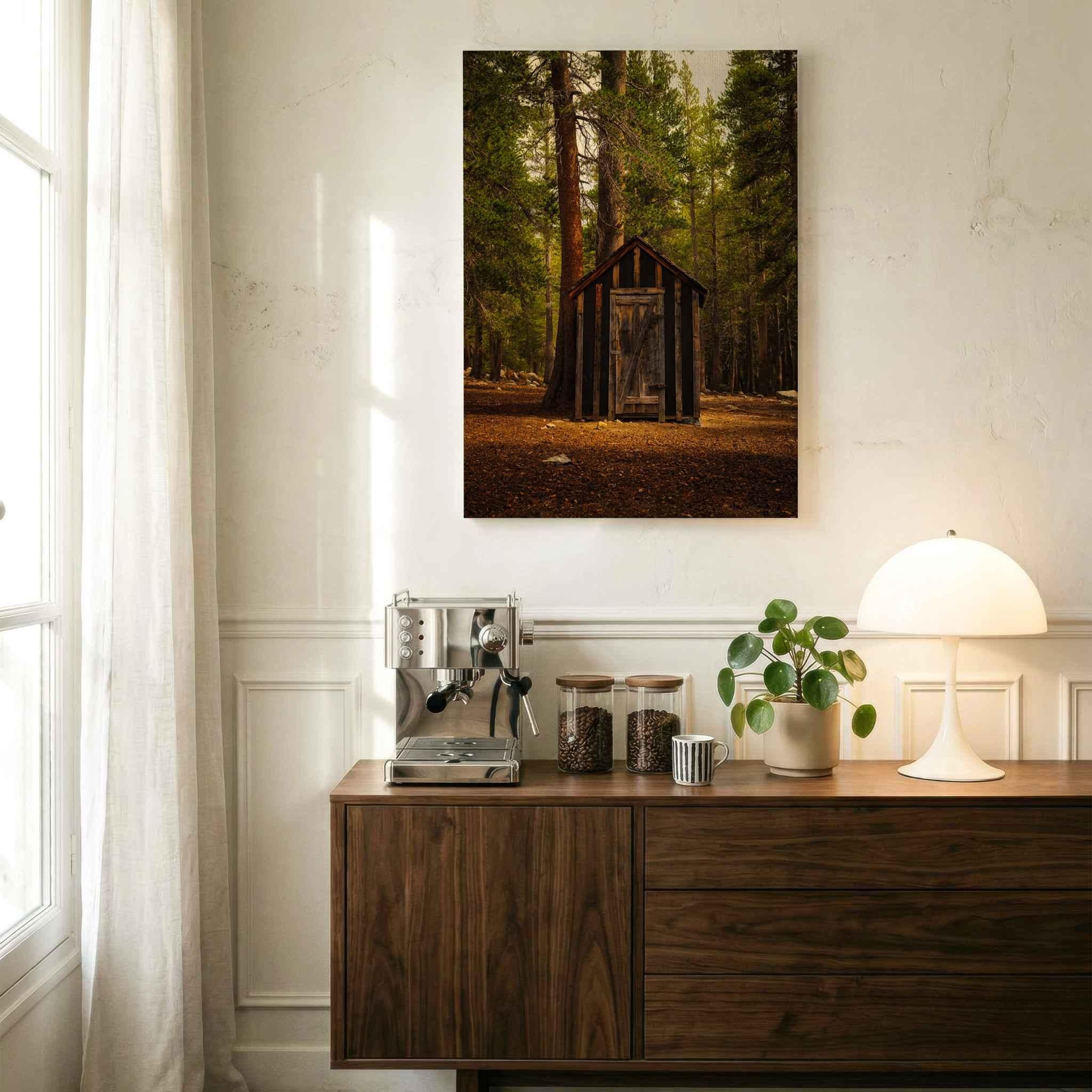 Mammoth Lakes forest canvas wall art featuring a rustic wooden outhouse displayed above a wood cabinet in a warm modern interior.