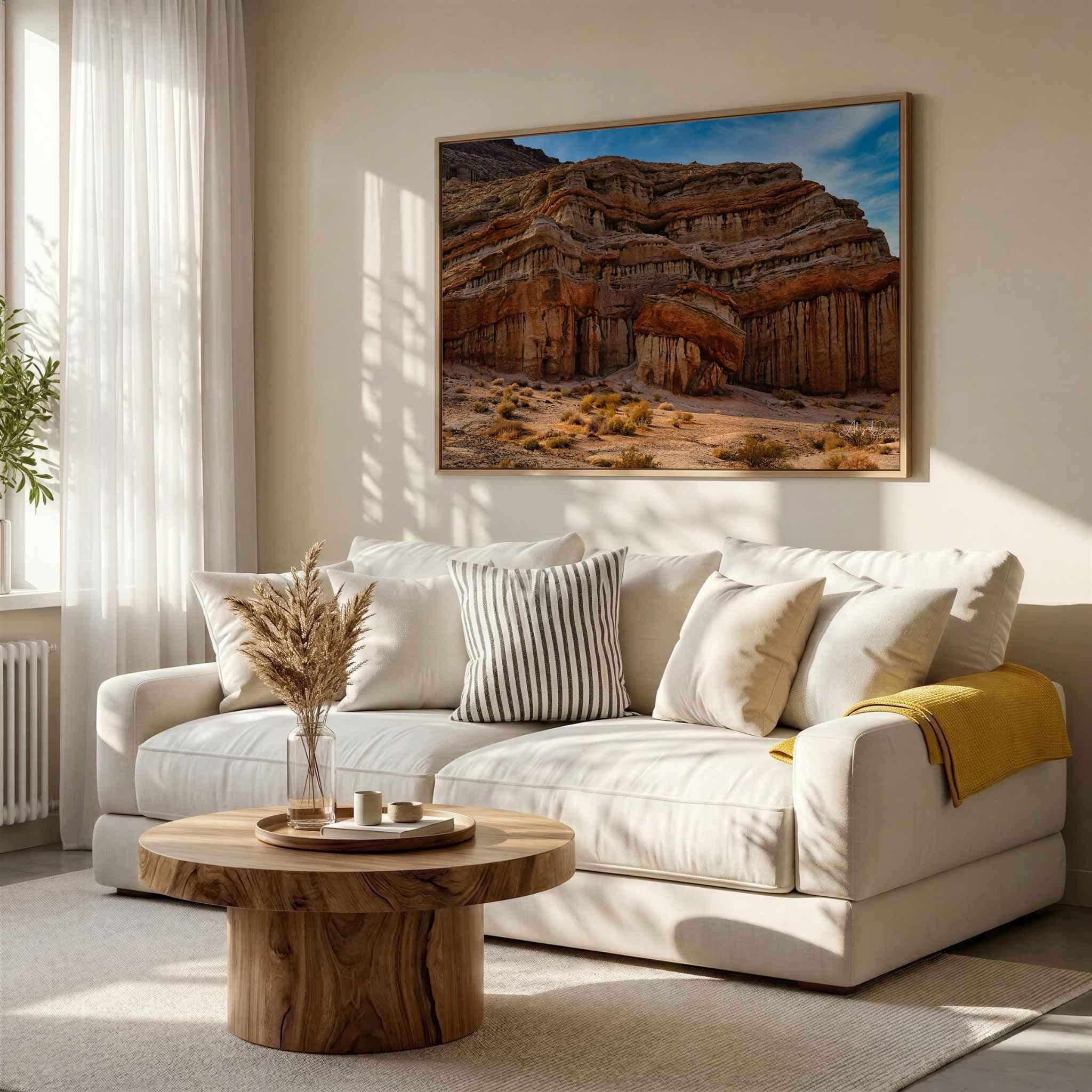 Sculpted by Time desert landscape wall art displayed above a cream sofa in a warm neutral living room with natural wood accents.