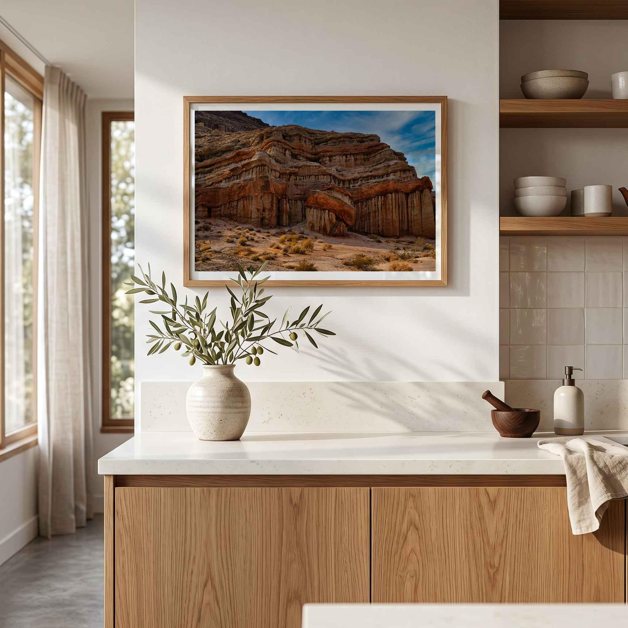 Sculpted by Time framed desert landscape fine art print displayed in a warm modern kitchen with natural wood cabinetry and neutral decor.