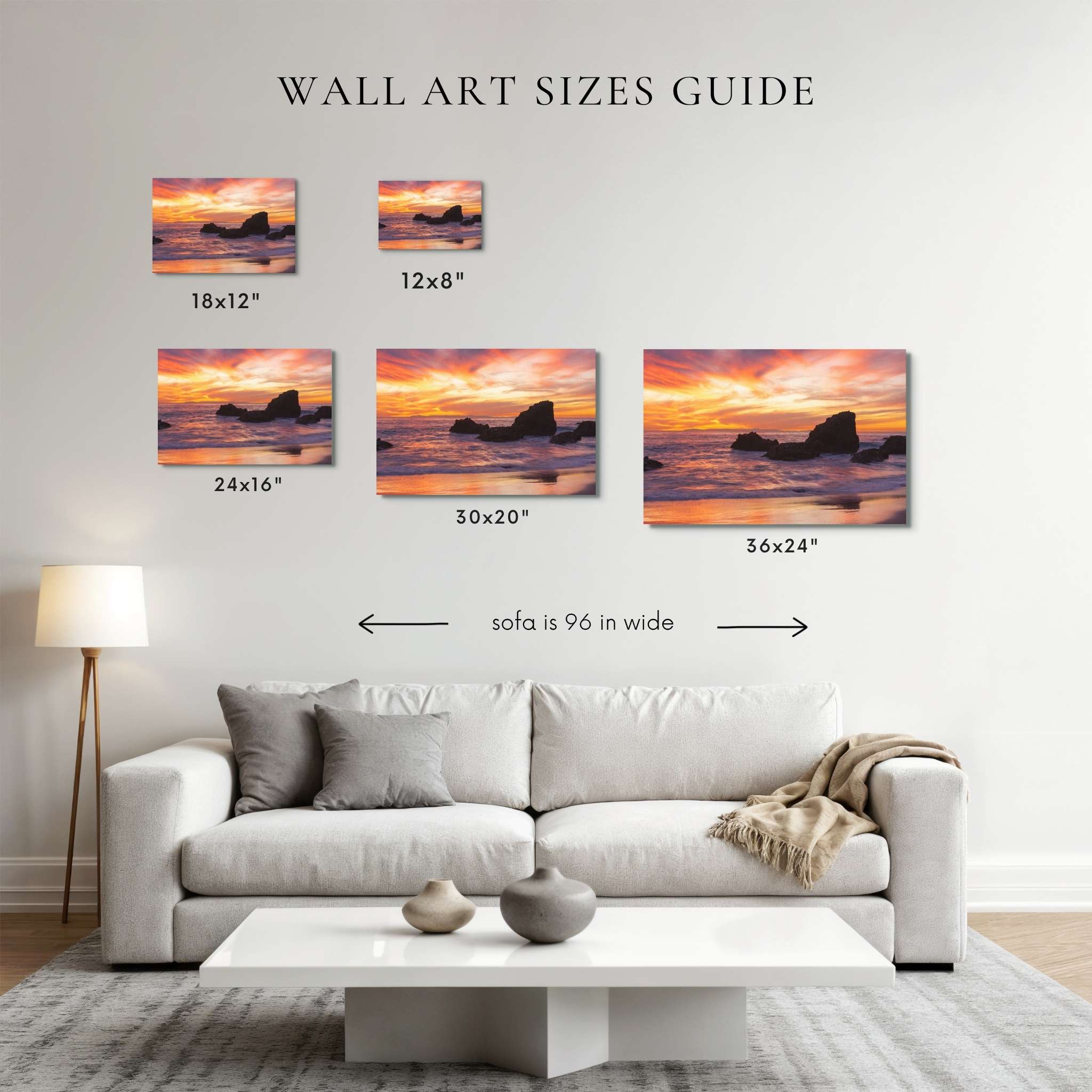 A wall art sizes guide showing five framed coastal sunset prints labeled 18x12", 12x8", 24x16", 30x20", and 36x24" above a light gray sofa in a living room. Text reads 'WALL ART SIZES GUIDE' and 'sofa is 96 in wide'.