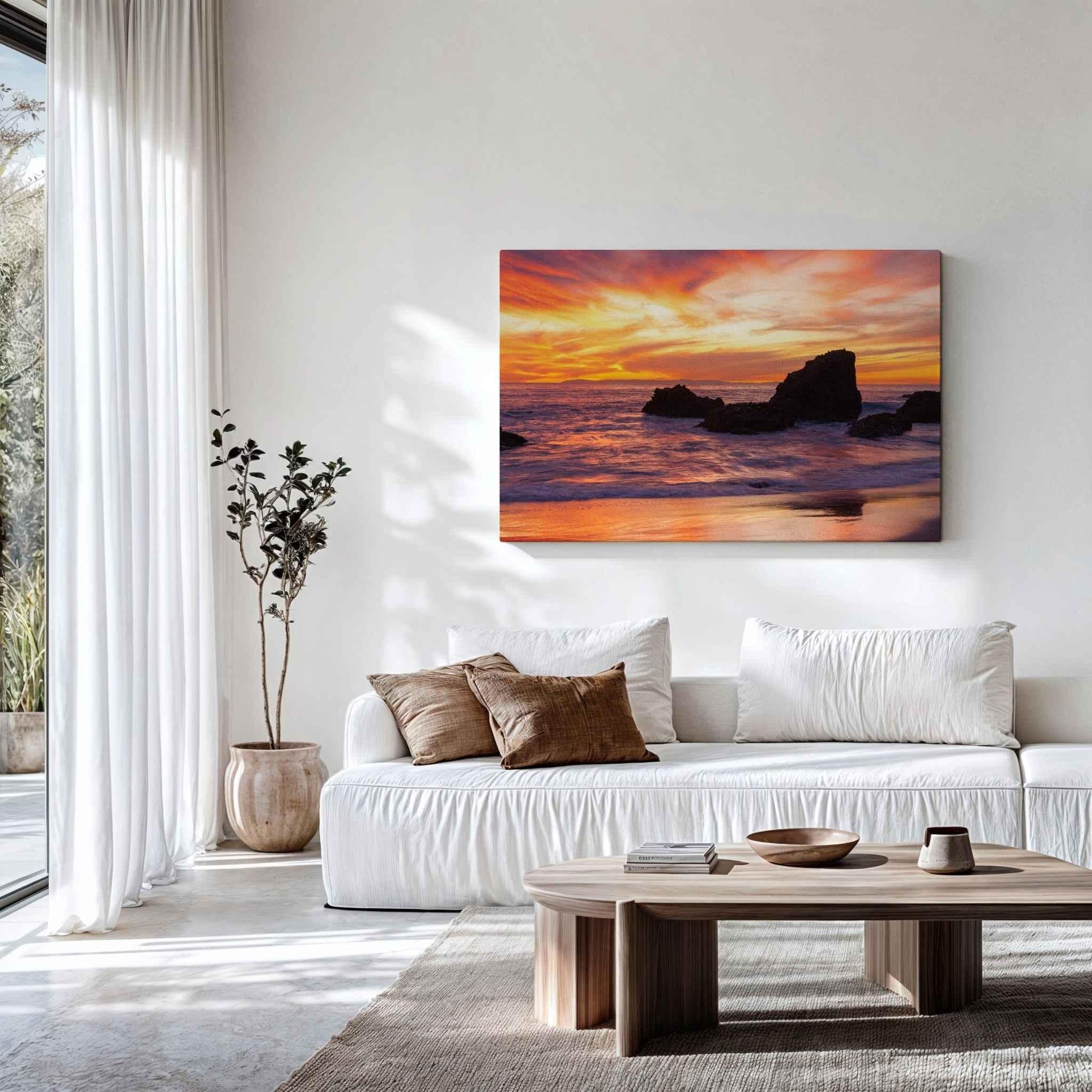 Sherbet Sunset canvas print by Abigail Diane Photography displayed above a white sofa, featuring a glowing orange and pink Laguna Beach sunset over the Pacific Ocean.