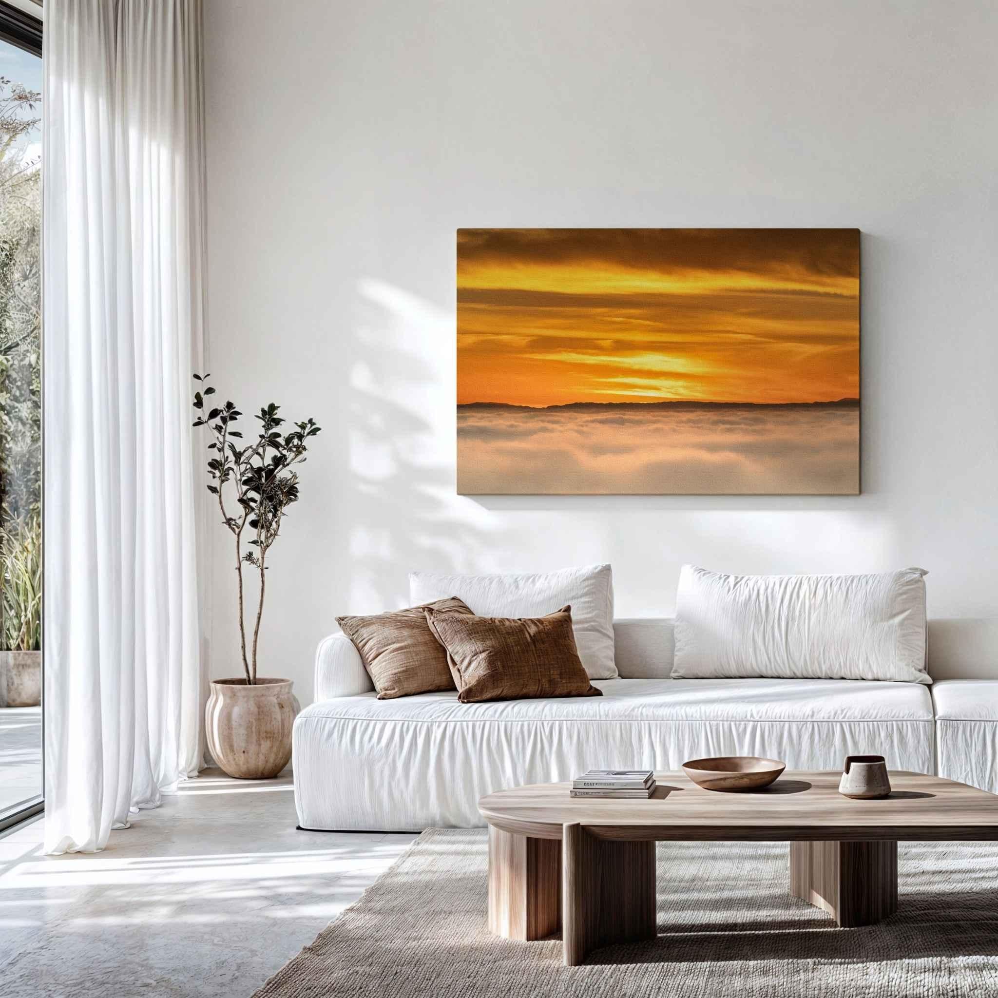 Large gallery-wrapped canvas print of Soaring Above the Clouds by Abigail Diane Photography displayed above a white sofa in a contemporary living room, featuring a golden sunset above a sea of clouds over Laguna Beach, California.