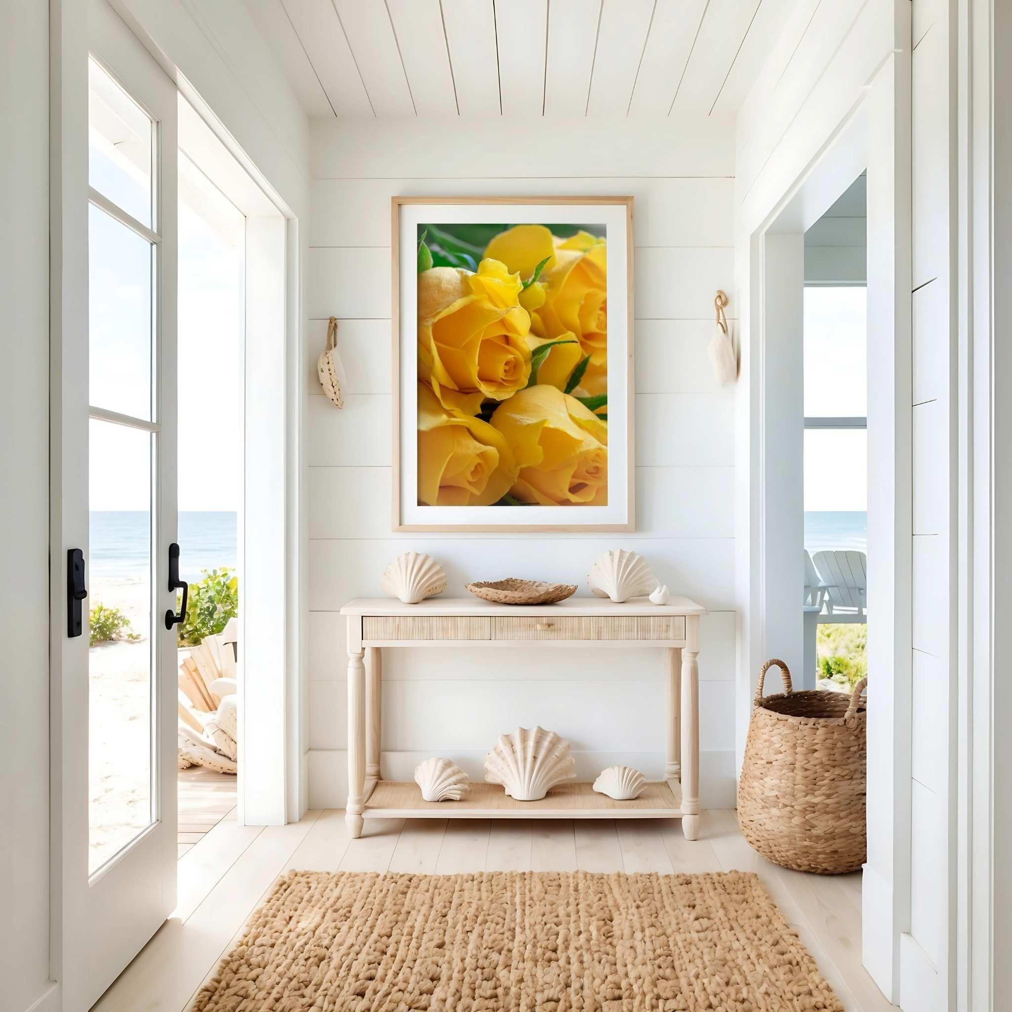 Sunlit Petal Reverie yellow rose photography by Abigail Diane Photography displayed in a natural wood frame within a bright coastal entryway featuring seashell décor, woven textures, and ocean views beyond the doorway.