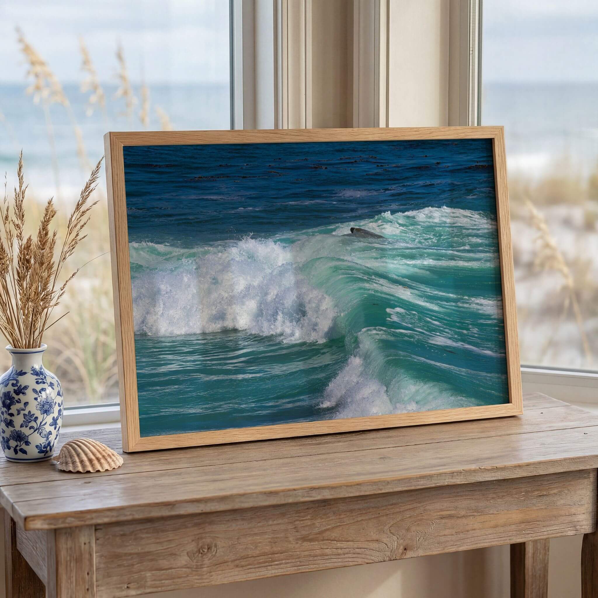 Framed Turquoise Healing Waves fine art print displayed on a coastal console table overlooking the ocean, showcasing powerful turquoise surf captured in Laguna Beach, California. Coastal wall décor by Abigail Diane Photography.