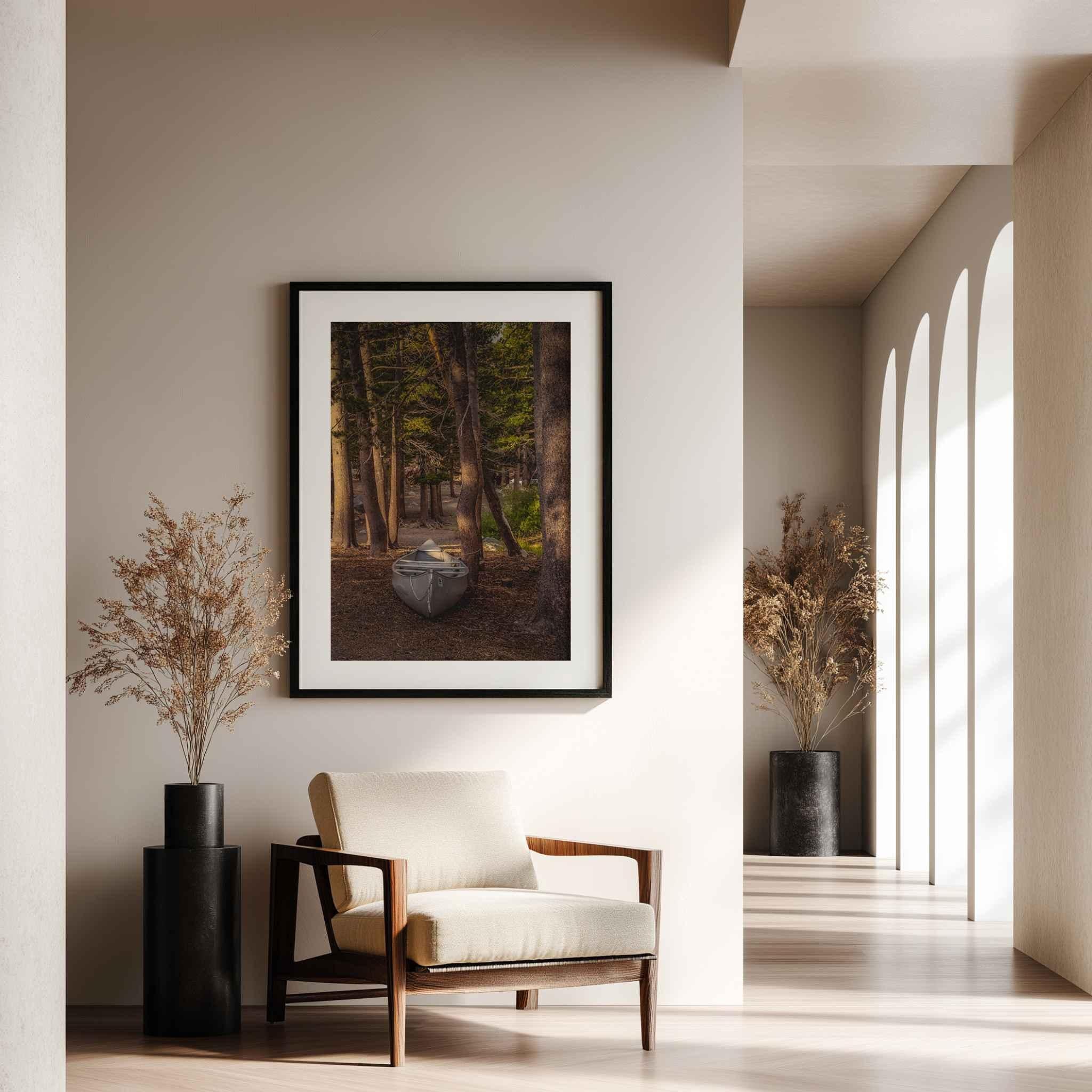 Waiting for the Water framed fine art print featuring a canoe among the forest trees displayed in a warm modern neutral interior.