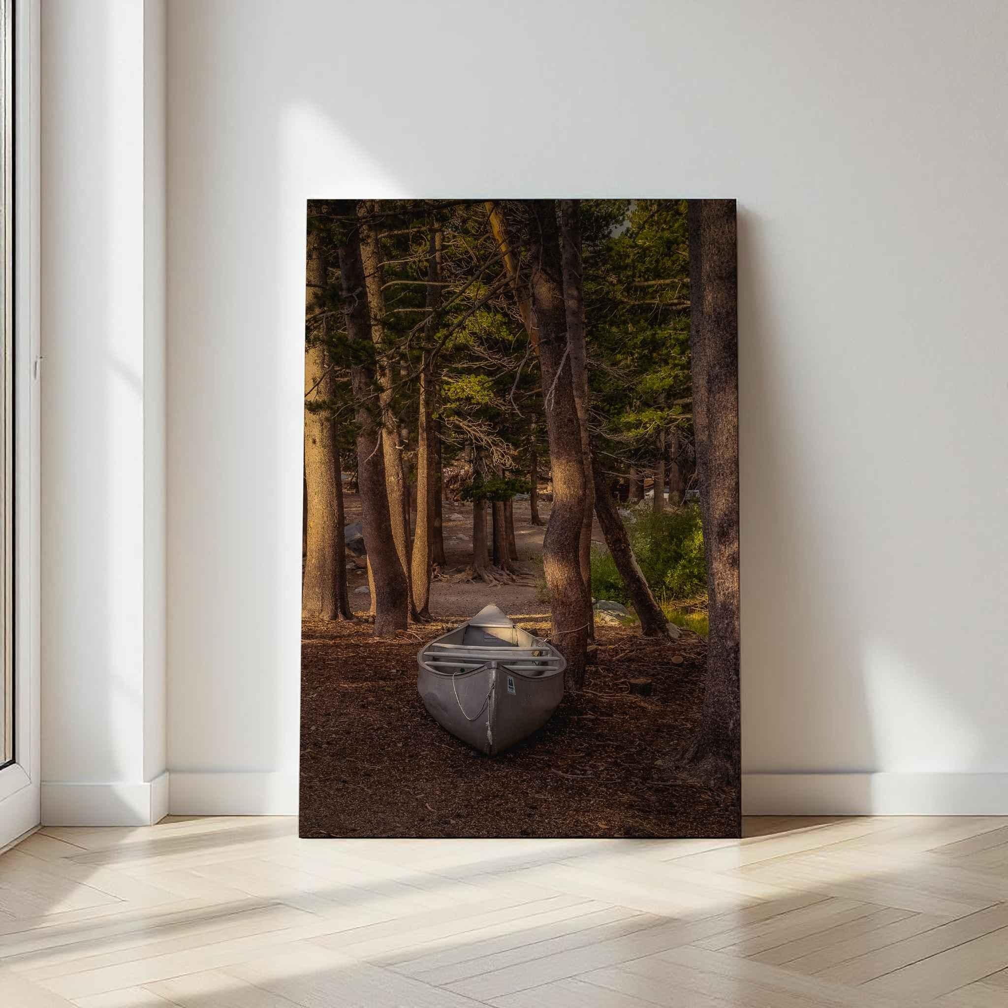 Waiting for the Water metal print displayed against a light wall, featuring a canoe resting among sunlit pine trees near Mammoth Lakes in California’s Eastern Sierra.