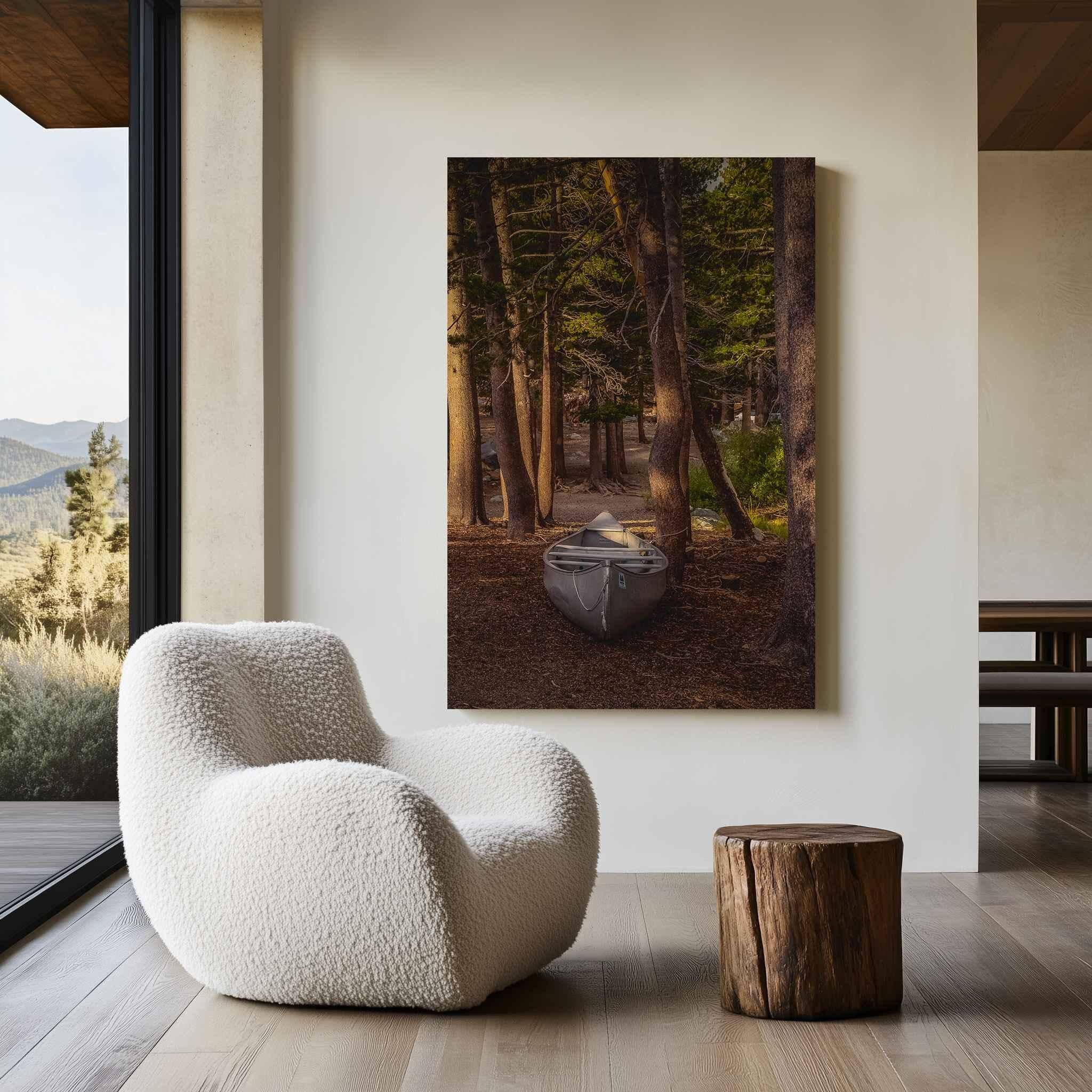 Waiting for the Water metal print displayed above a sculptural wood console, featuring a canoe resting among pine trees near Mammoth Lakes in California’s Eastern Sierra.