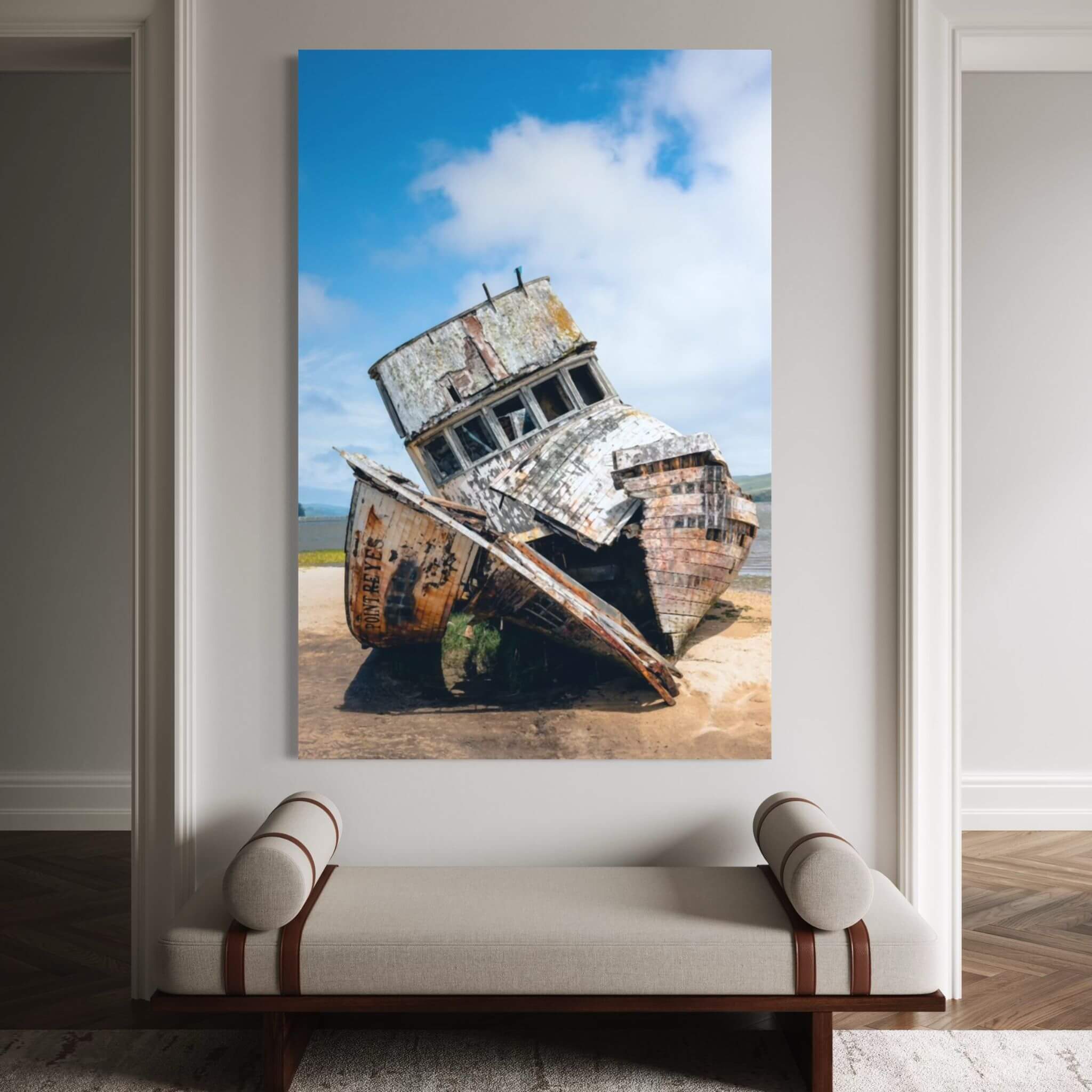Weathered Echoes Point Reyes shipwreck metal wall art displayed above an upholstered bench in an elegant neutral hallway interior.