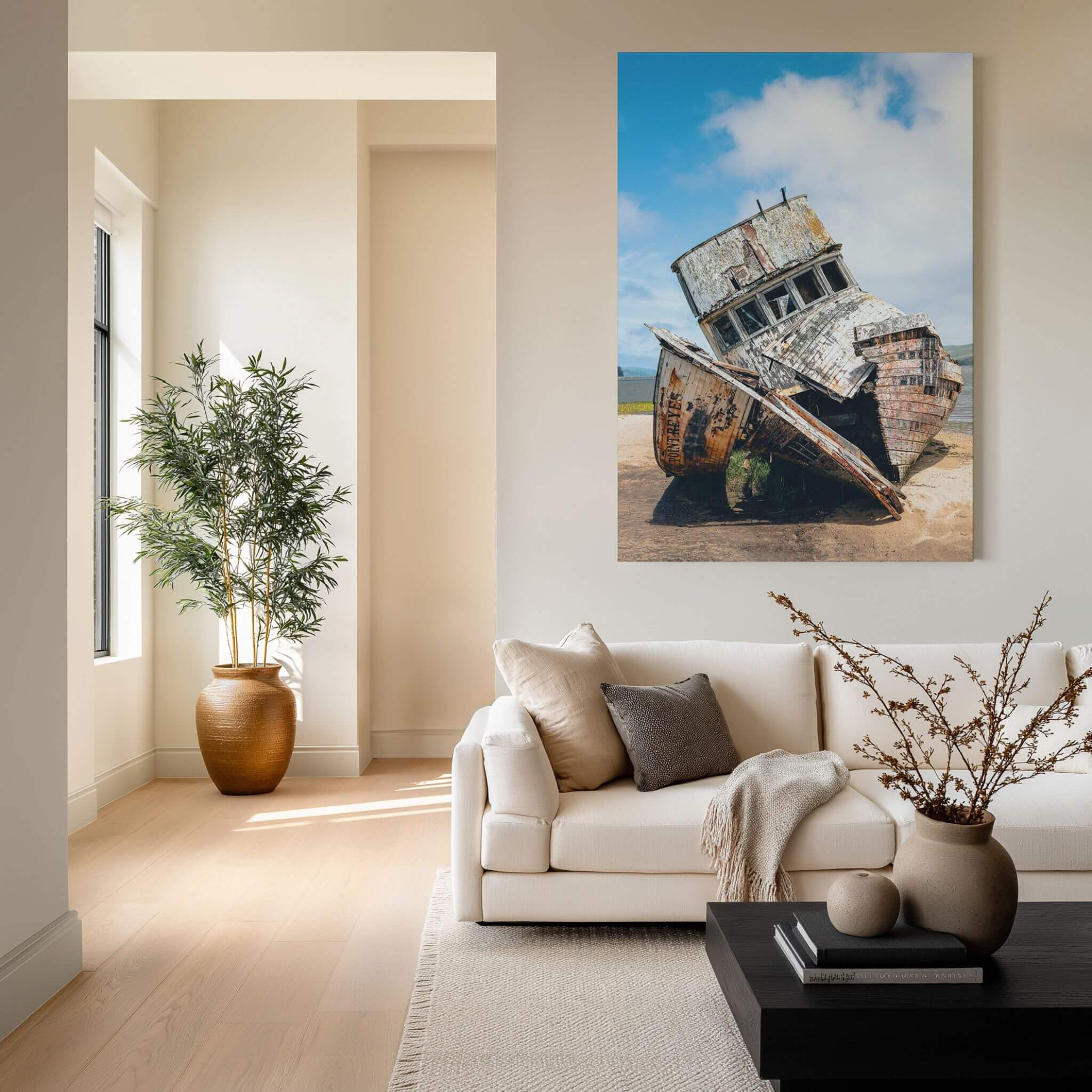 Weathered Echoes Point Reyes shipwreck metal wall art displayed above a cream sofa in a warm contemporary living room with natural wood accents.