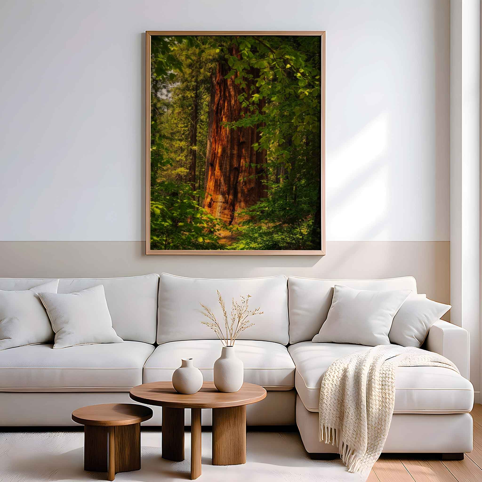 Where Giants Awaken fine art print by Abigail Diane Photography displayed above a contemporary sofa in a bright living room, showcasing a sunlit giant sequoia surrounded by lush woodland in Yosemite National Park, California.