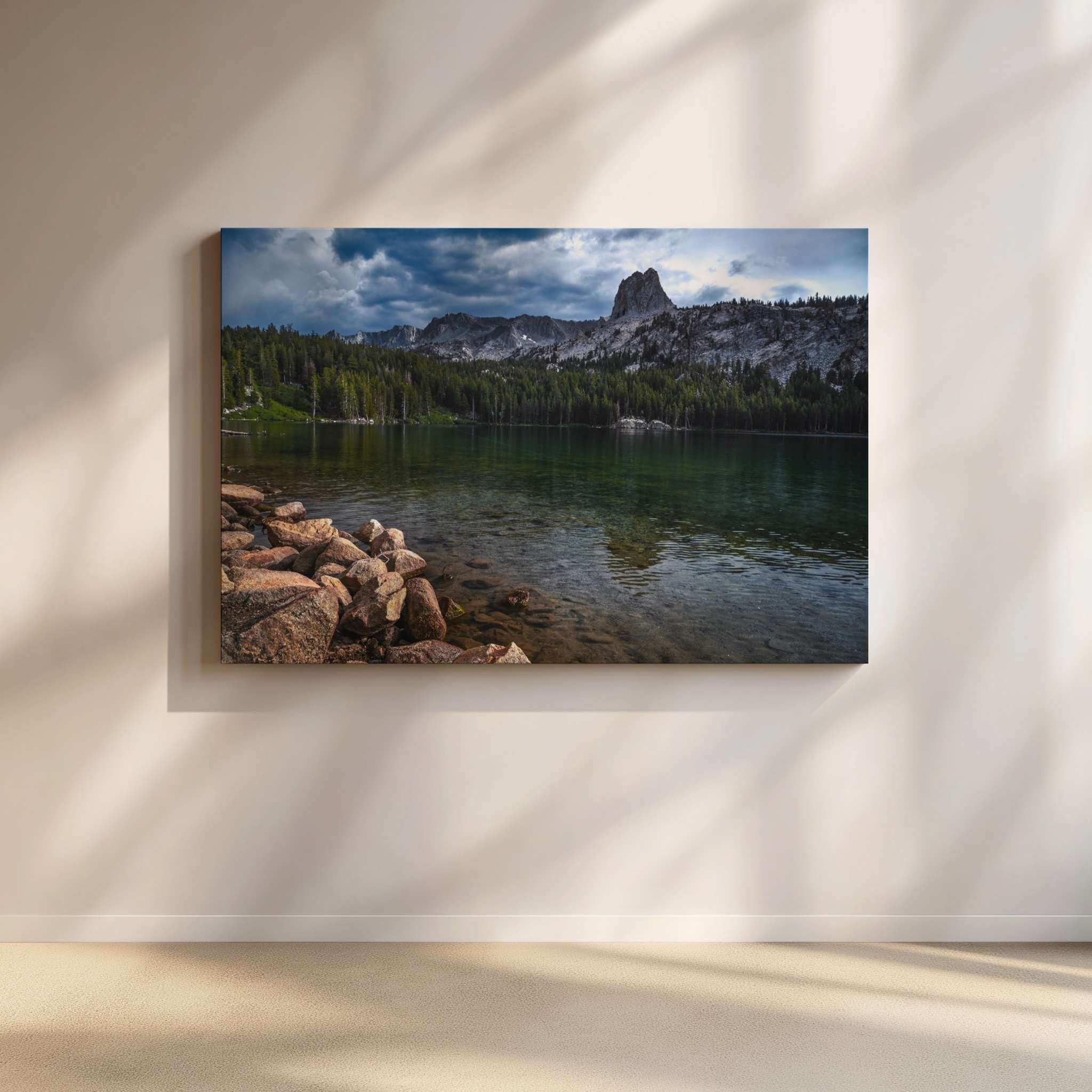Large gallery-wrapped canvas wall art featuring Where Mountains Meet Stillness, showcasing a peaceful mountain lake surrounded by granite peaks and pine forests in Mammoth Lakes, California, displayed on a warm neutral wall with soft natural sunlight in a contemporary home by Abigail Diane Photography.