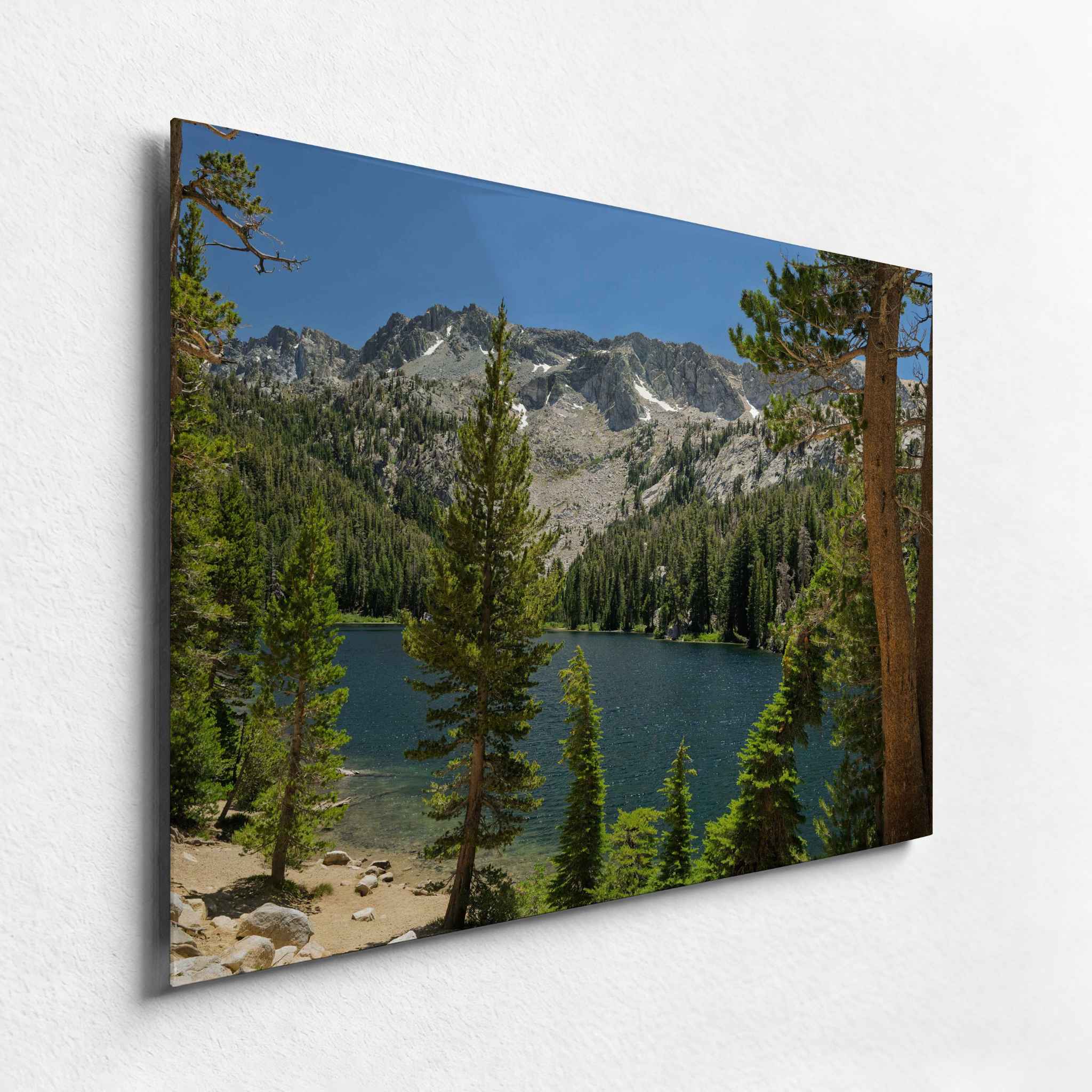 TJ Lake in Mammoth Lakes California surrounded by pine trees and rugged Sierra peaks, shown as an HD metal print from an angled side view.
